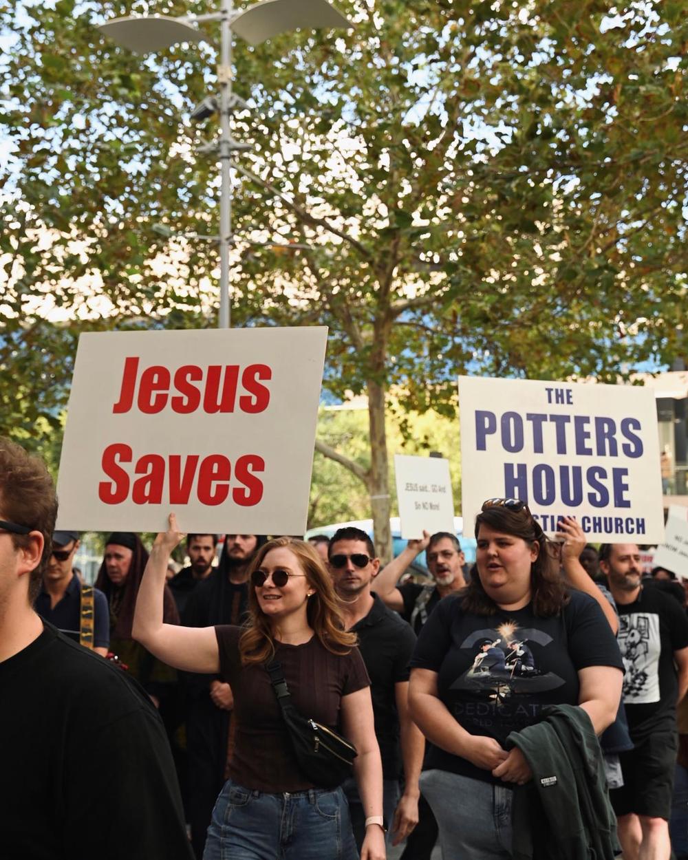 Street outreach with a 'Jesus Saves' sign