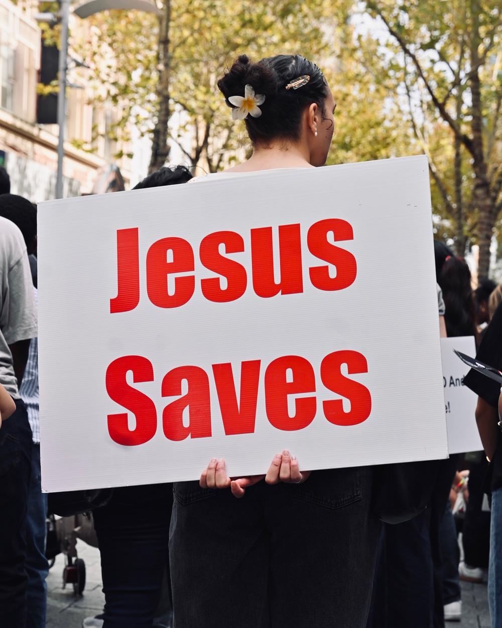 A church member holding a 'Jesus Saves' placard